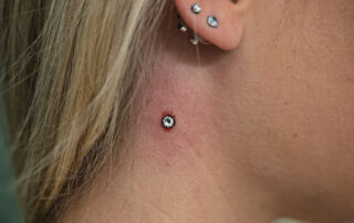 Frisch gesetzter Dermal Anchor am Hals mit leicht geröteter Haut – professionelle Durchführung Berlin