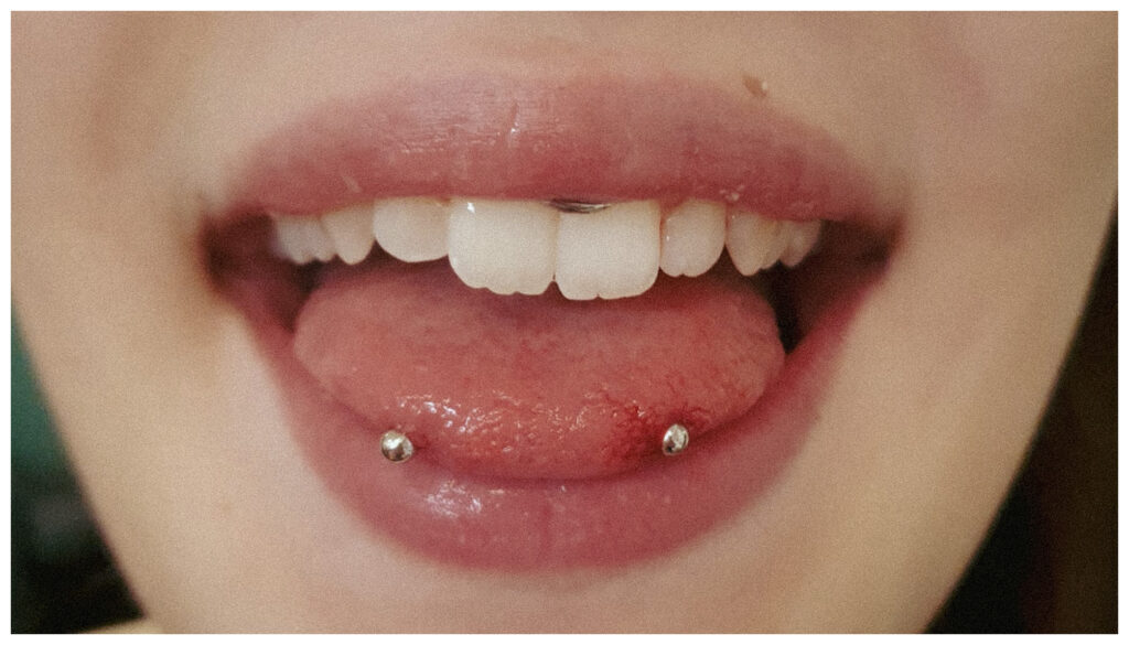 Snake Eye Piercing auf der Zungenspitze mit zwei Kugeln im Autark Tattoo & Piercing Studio Berlin Charlottenburg.